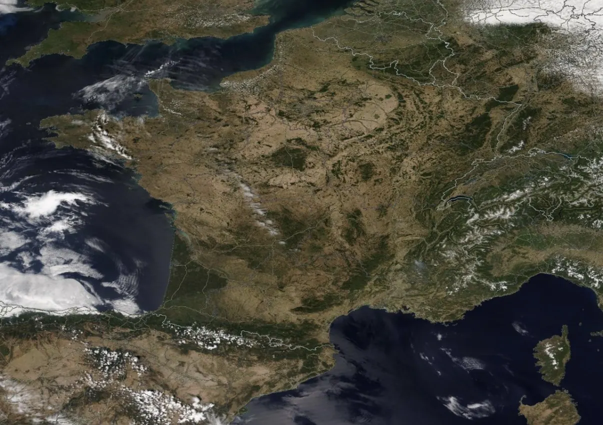 Vue satellite de la France en été : l'essentiel du territoire apparaît brun et sec, seuls les massifs montagneux et quelques forêts restent verts.
