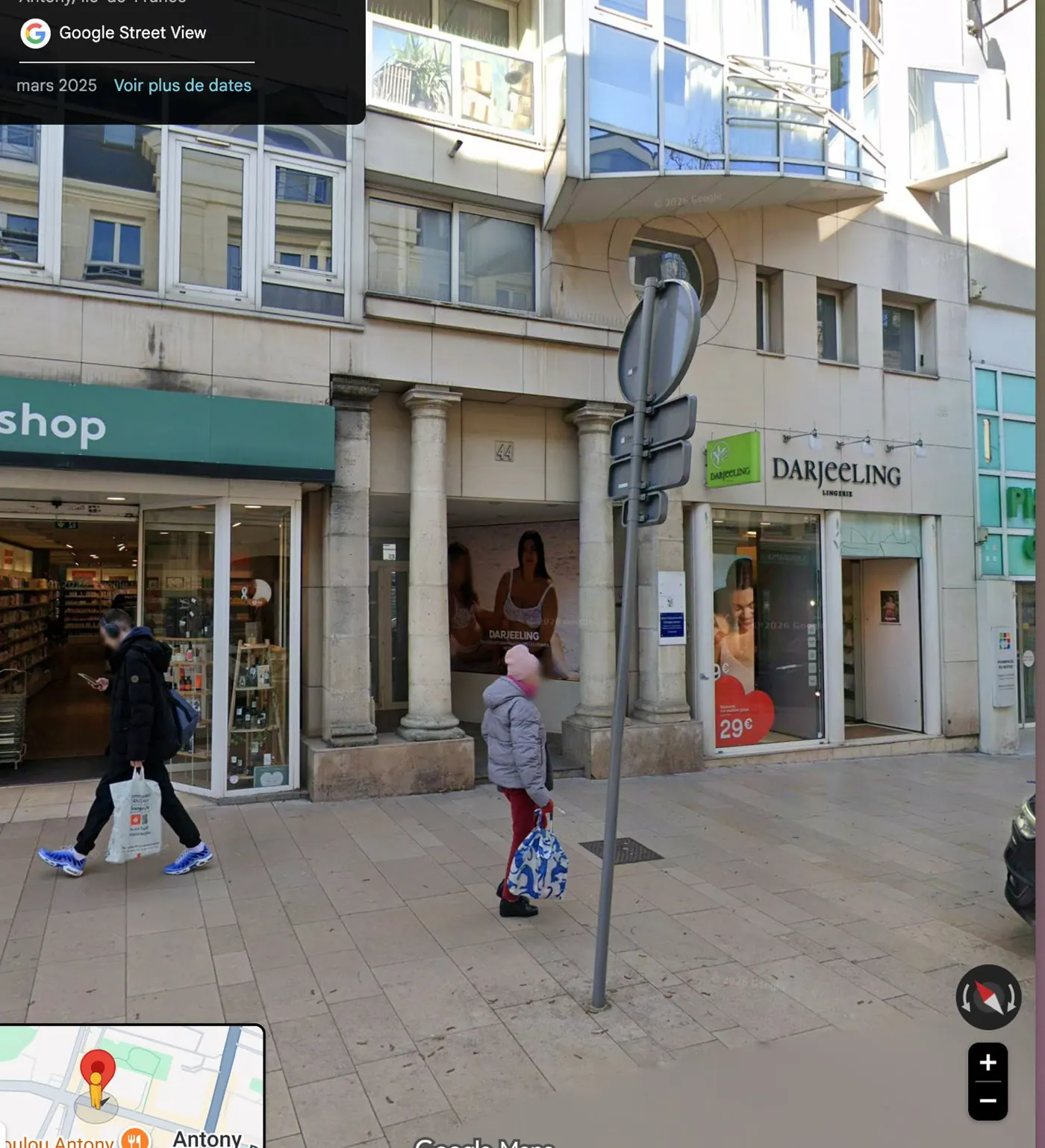 Vue Street View de mars 2025 du 44 rue Mounié : deux colonnes de pierre, seul vestige de l'ancienne mairie, encadrent l'entrée entre une pharmacie et une boutique de lingerie.